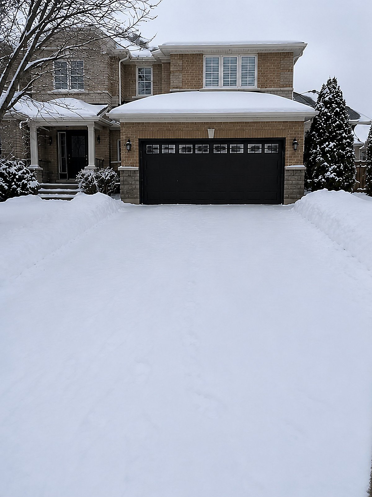 Snow-covered residential driveway before snow removal service